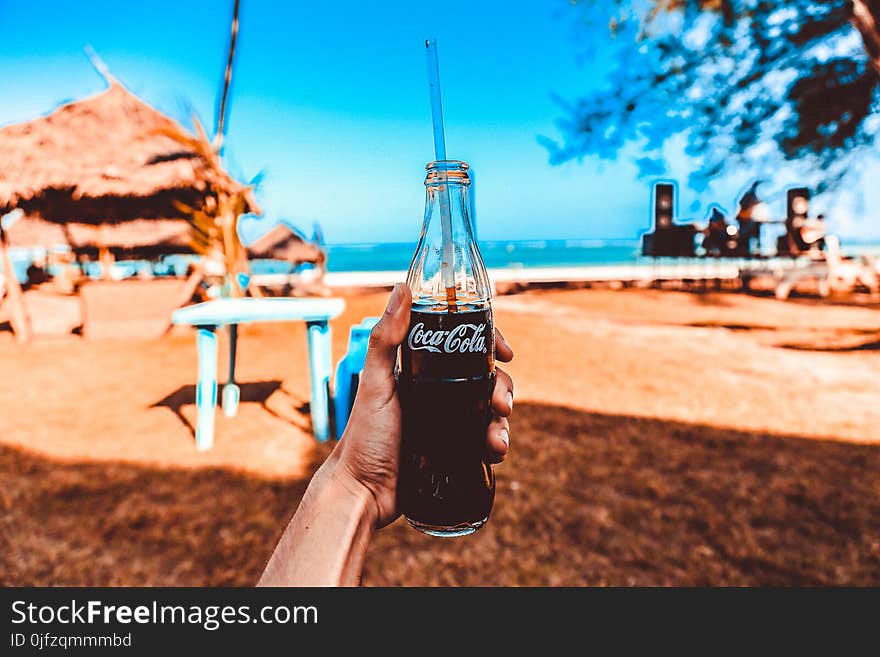 Person Holding Coca-cola Glass Bottle