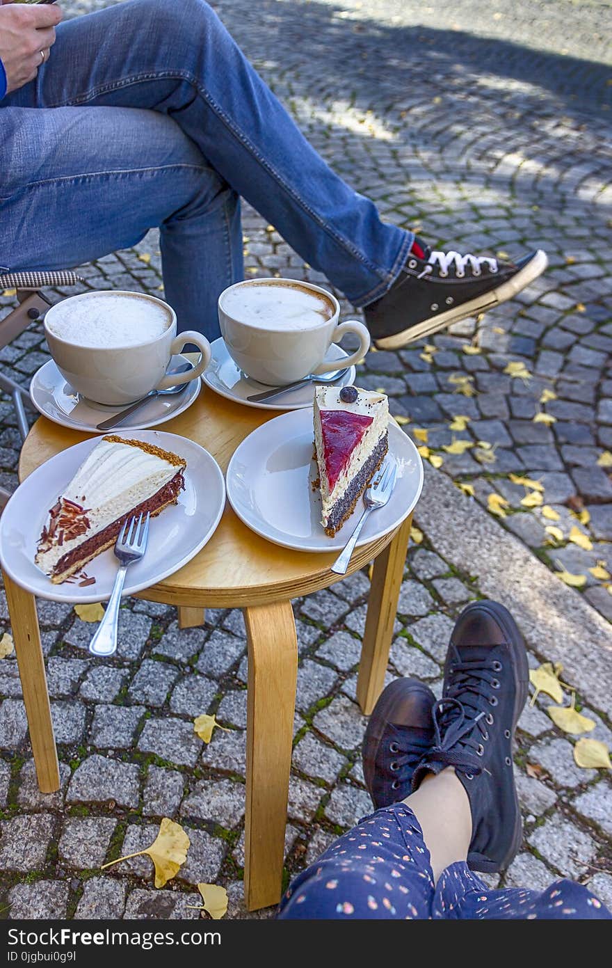 Street cafe in Weimar, Germany. Two cups of coffee latte and a pieces of cake