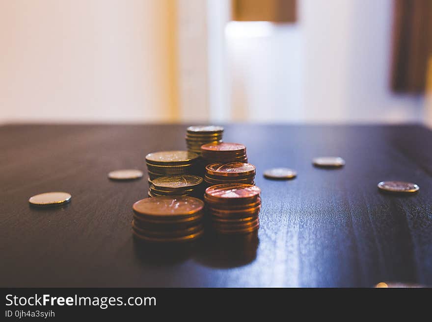 Pile of Brown Coins on Brown Wooden Table Top