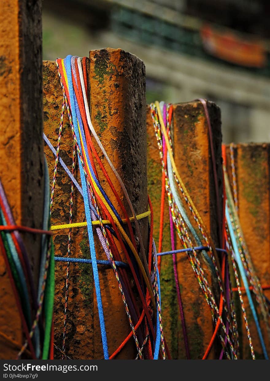 Brown Metal Fence With Blue Red and Yellow Rubber Band Selective Focus Photo