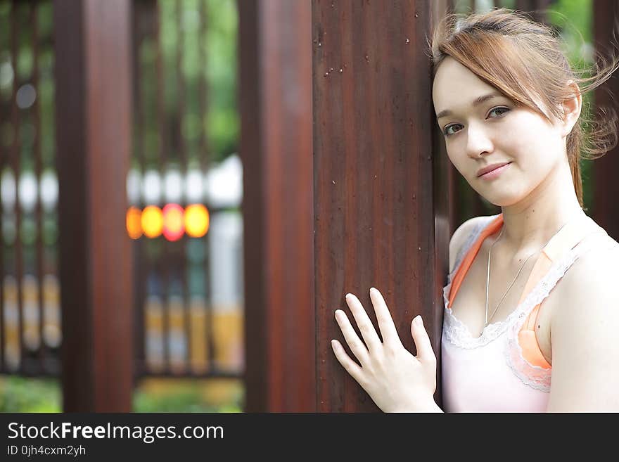 Woman in Tank Top on Wooden Post