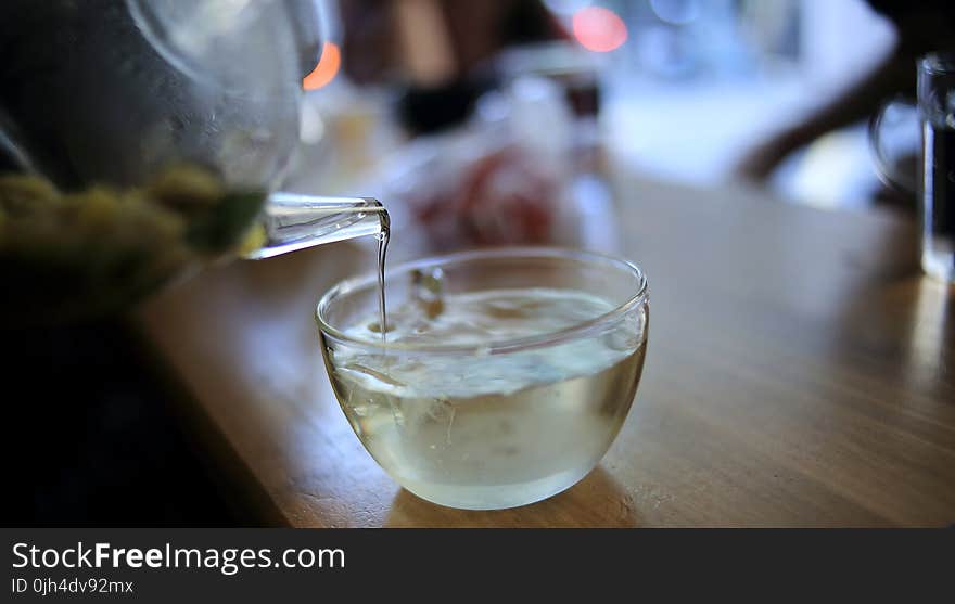 Clear Glass Pitcher Pouring Liquid on Clear Glass Cup