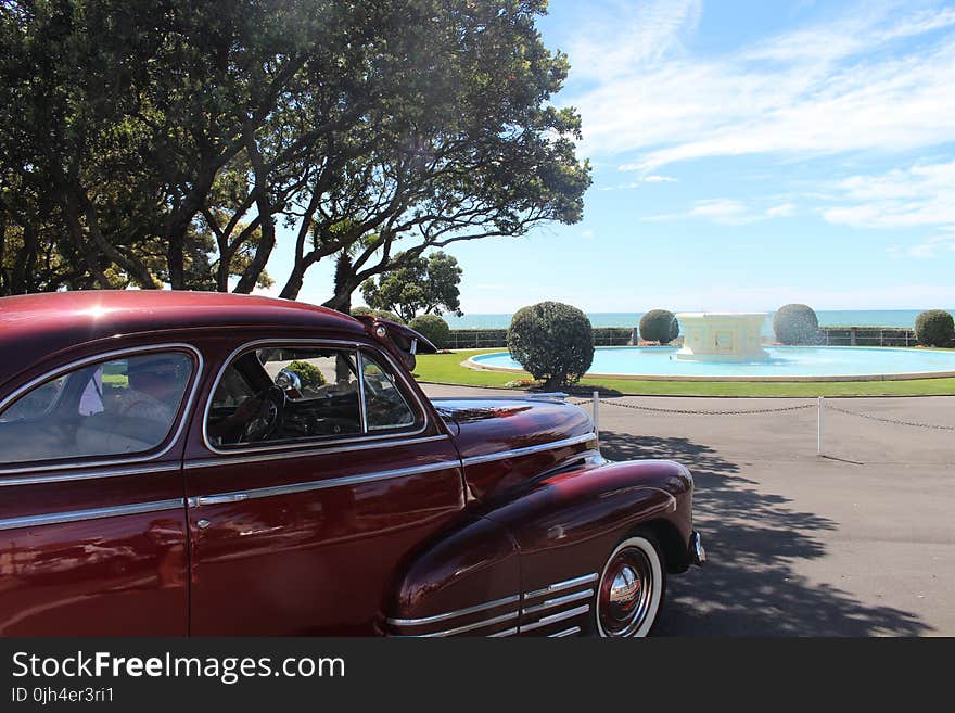 Red Classic Car Parked Near Tree during Daytime