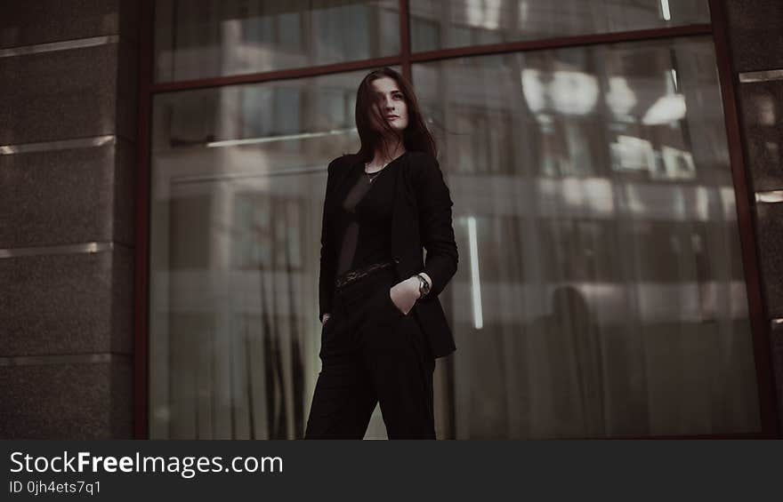 Woman Standing Near Clear Glass Window