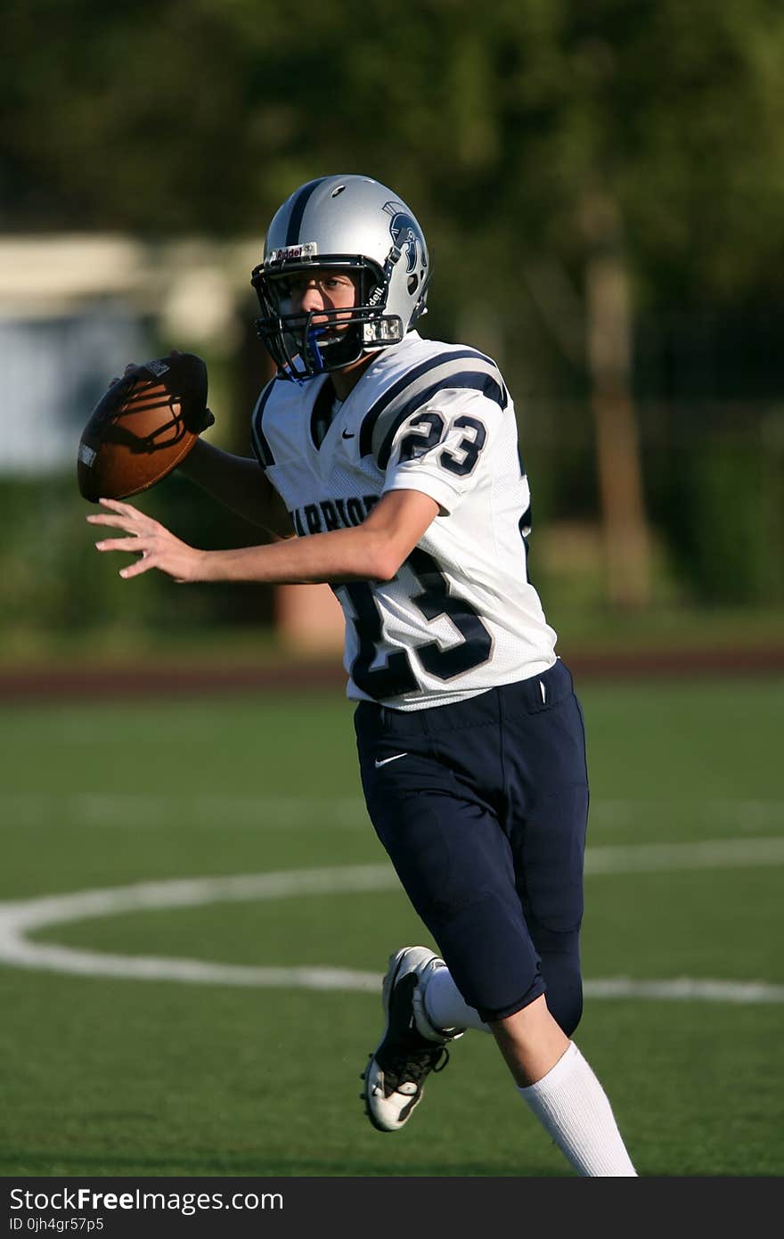 Man in White and Black Football Jersey Playing on Field during Daytime