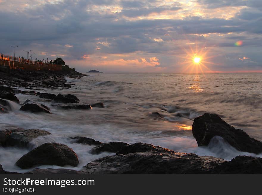 Rocks on Seashore during Sunset