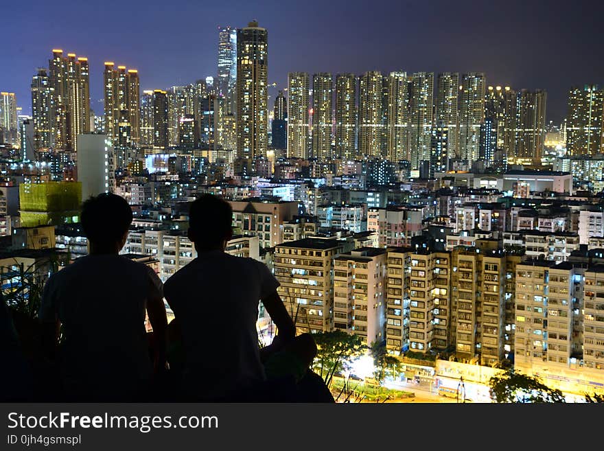 Silhouette of 2 Person on Top of the Building during Nighttime