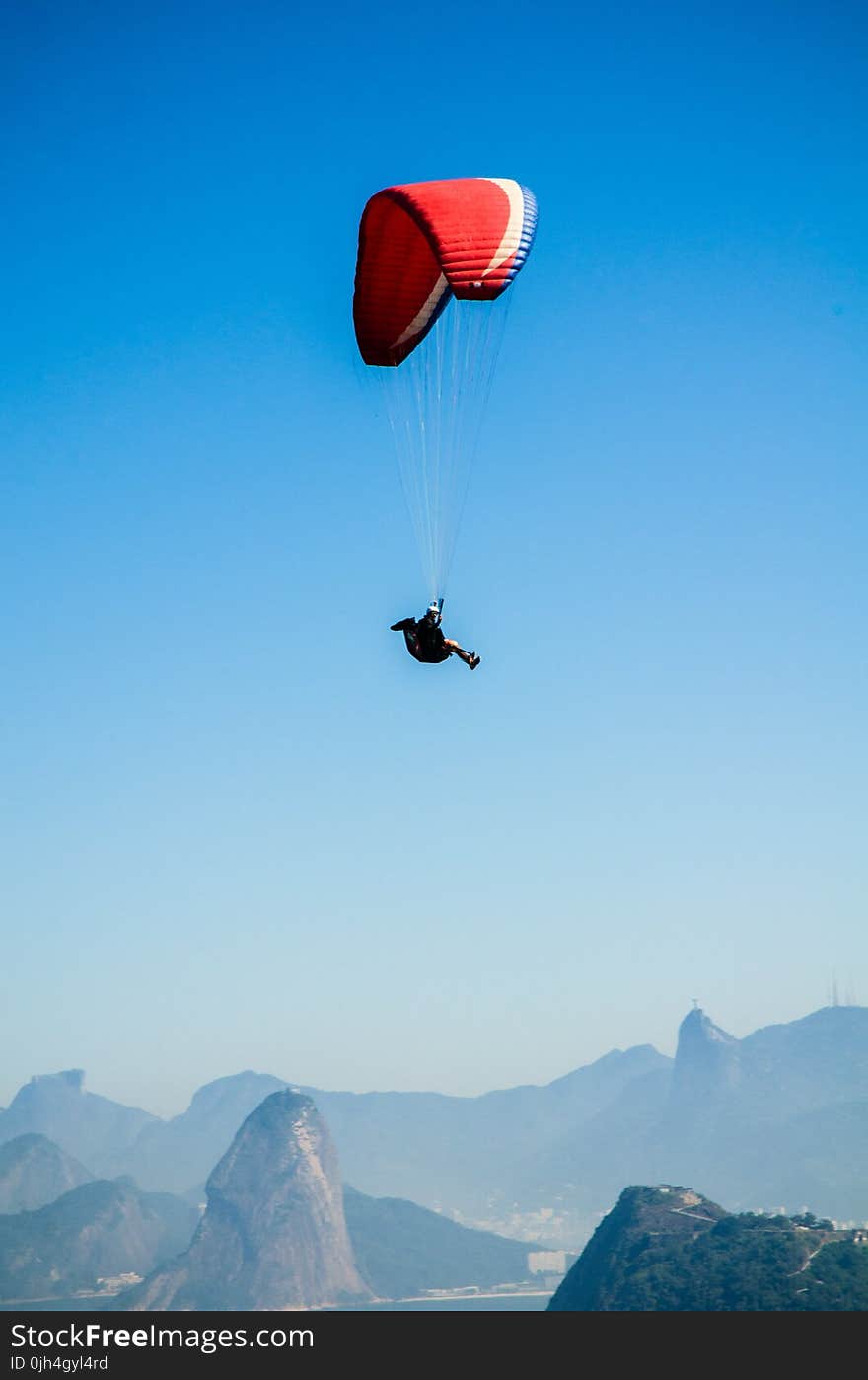 Red White Parachute on Top of Mountains during Daytime