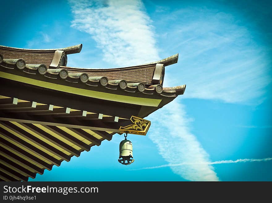 Yellow and Brown House Ceiling With White Hanging Lamp Under White and Blue Sky