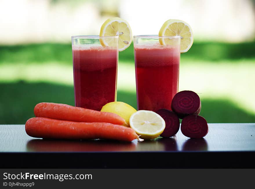 Carrot Fruit Beside Lemon Fruit on Black Wooden Table