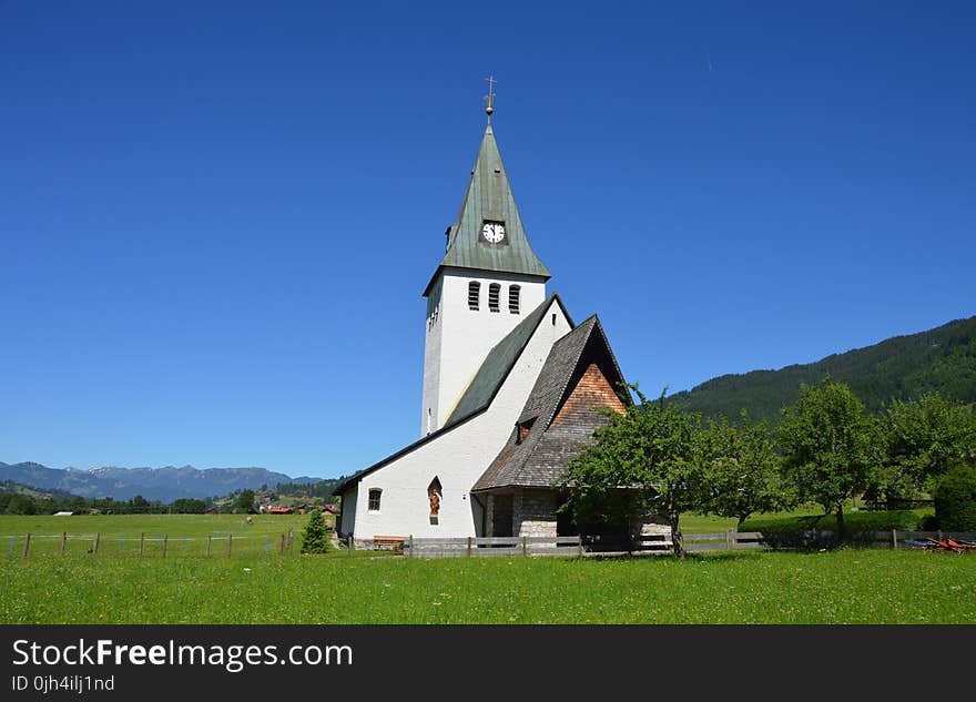 White and Gray Painted Chapel Near Green Open Field during Daytime