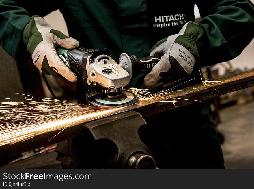 Person Holding Black and Gray Hitachi Angle Grinder