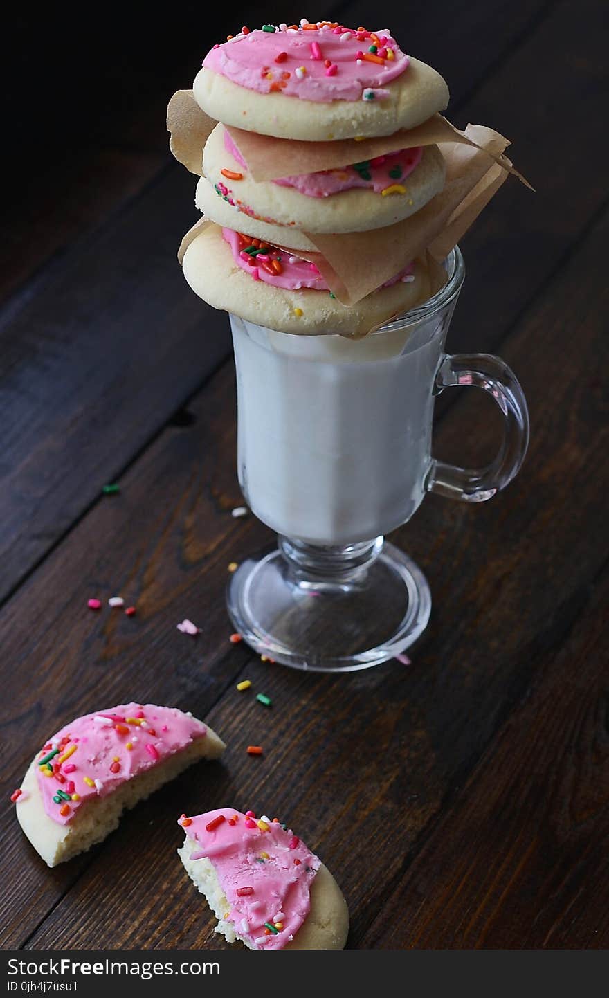 Cookies With Pink Cream on Top of Clear Short Stem Footed Mug With Milk