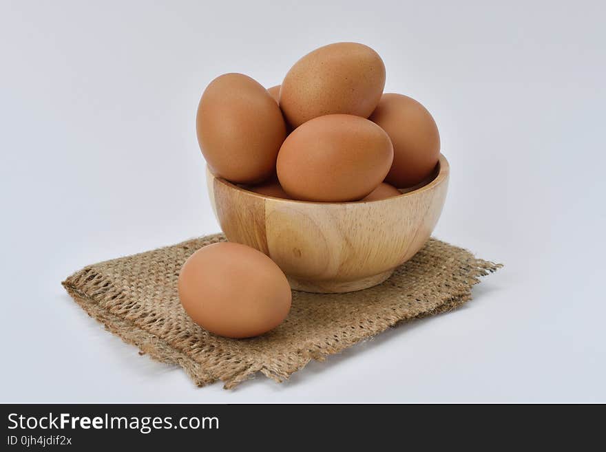 Brown Eggs on Brown Wooden Bowl on Beige Knit Textile