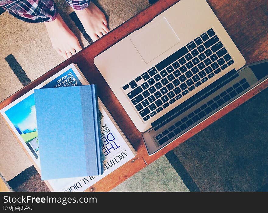 Macbook Air Beside 2 Books on Table