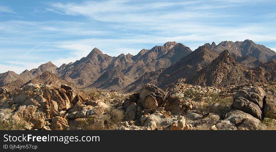 Landscape Photography of Brown Mountain Under White and Blue Cloudy Sky during Daytime