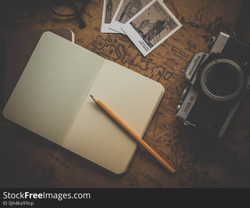 Yellow Pencil on White Book Near Camera