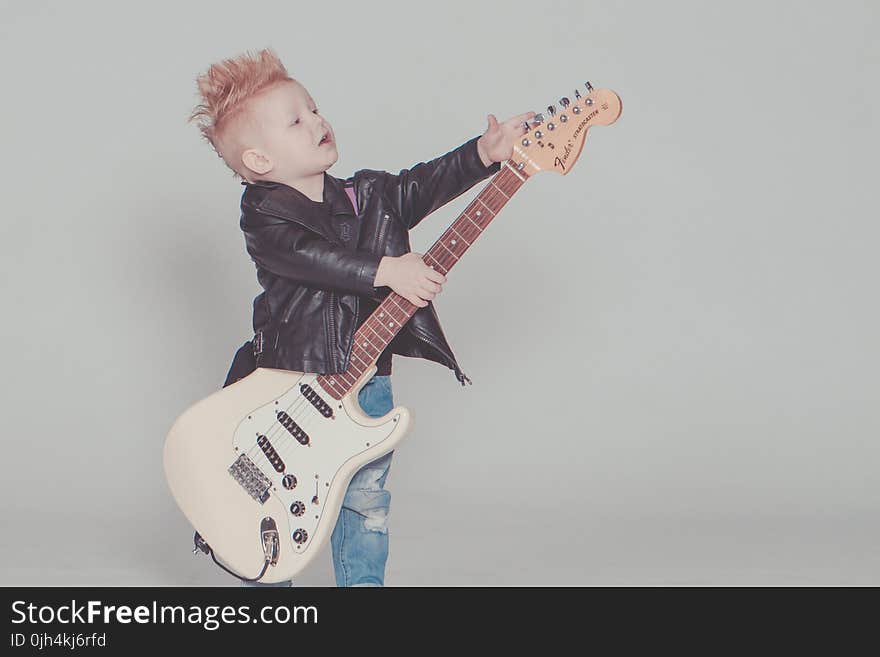 Boy Wearing Black Jacket Holding Electric Guitar