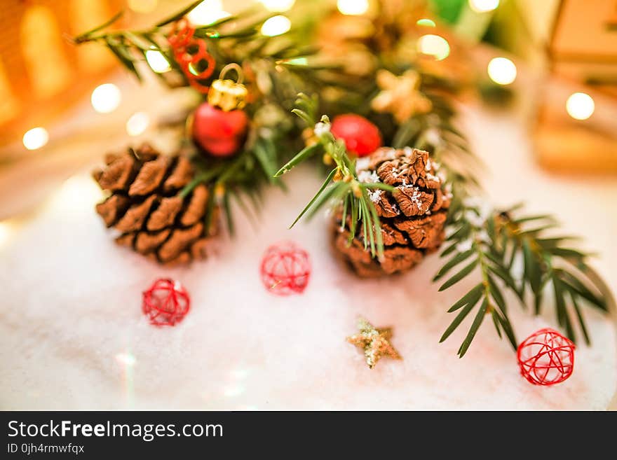 Shallow Focus Brown Pinecone Near Red and Black Ornament