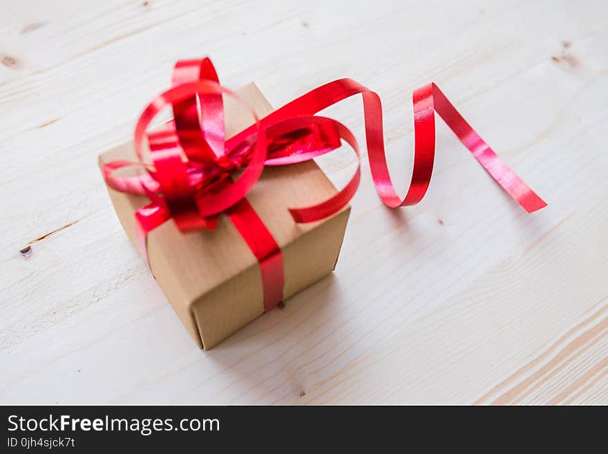 Red Ribbon on Brown Cardboard Box