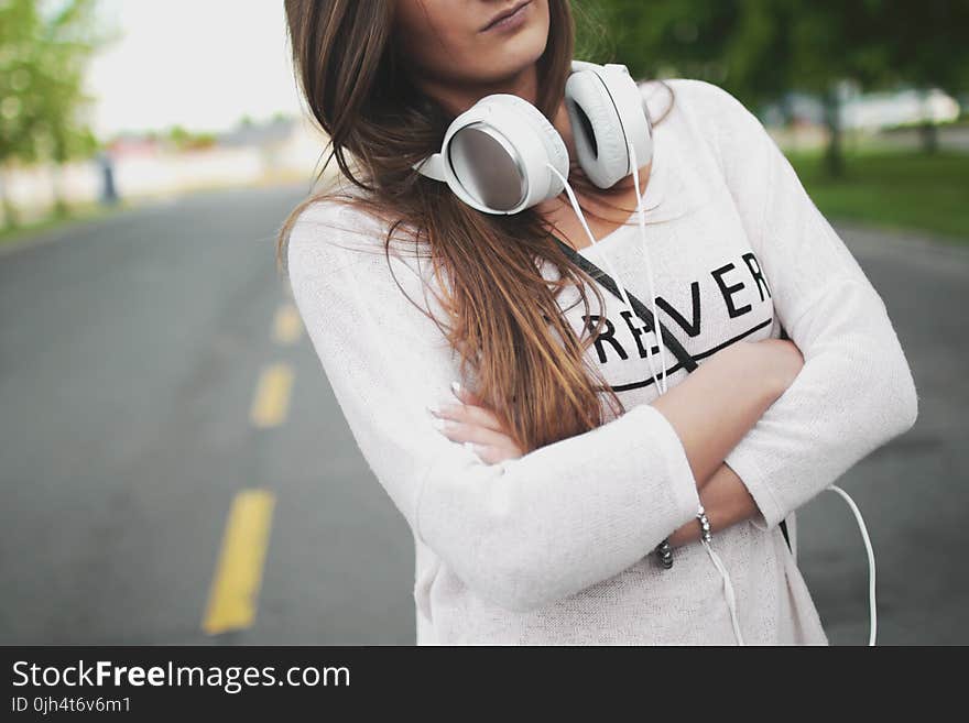 Woman in White Long Sleeve Shirt Standing on Center of Road during Day Time