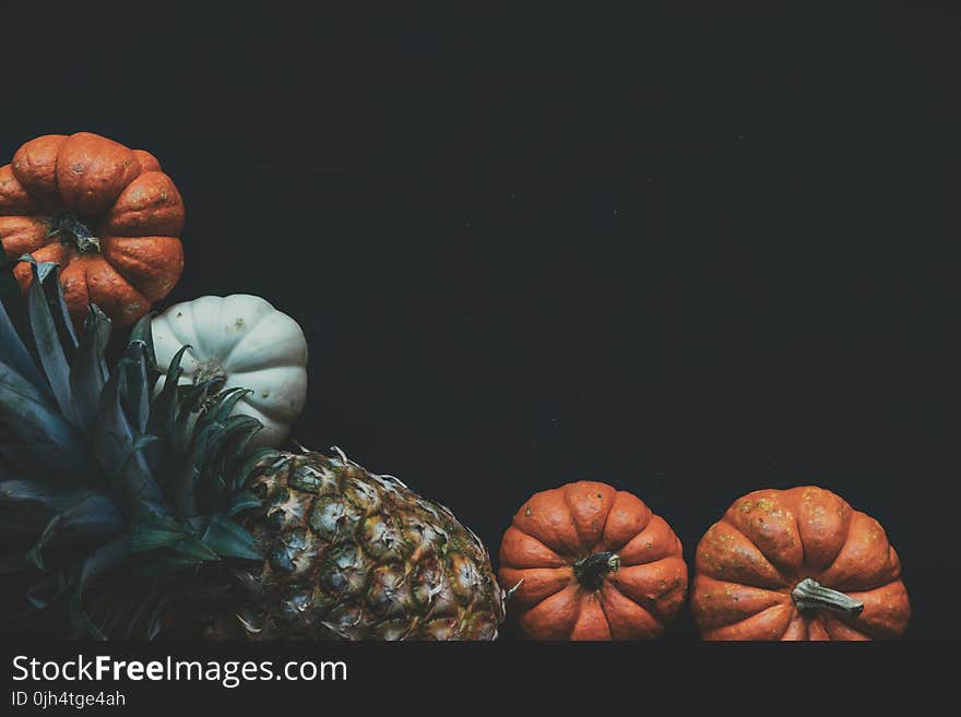 Photography of a Pineapple Fruit Near Two Squashes