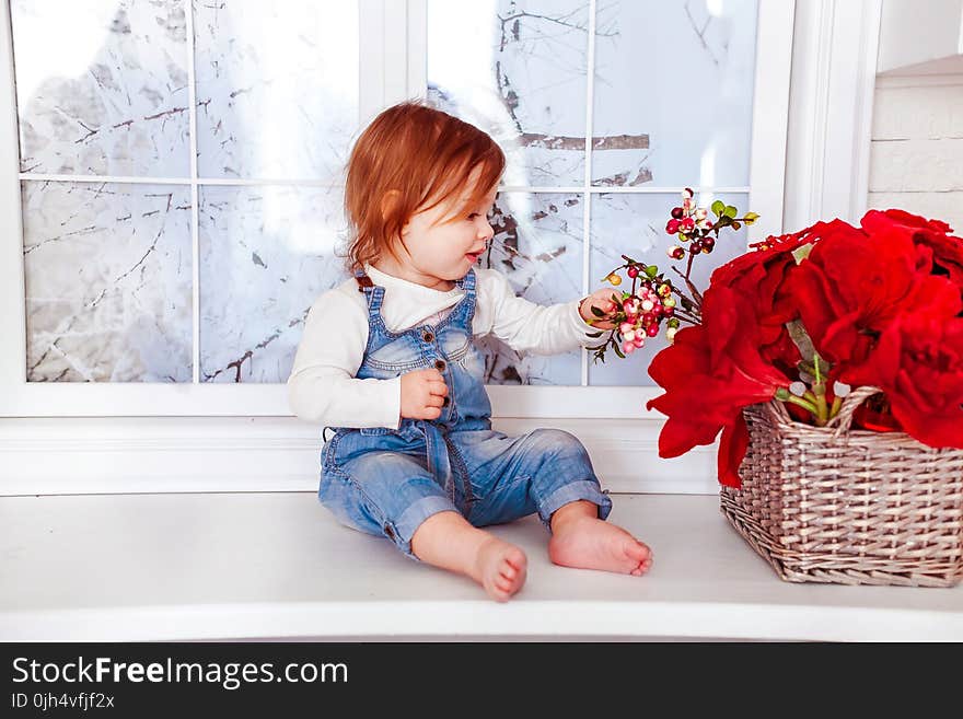 Kid&#x27;s Blue Denim Jumper Sitting on White Wooden Side Table