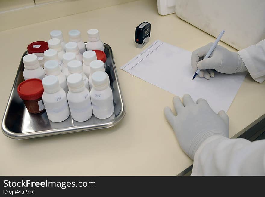 Person in White Hand Gloves Writing on White Paper