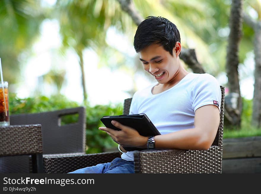 Man in White Shirt Using Tablet Computer Shallow Focus Photography