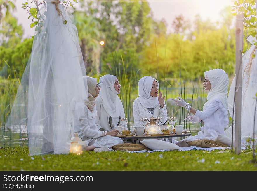 4 Women in White Abaya Wedding Gown Having Picnic Near Trees