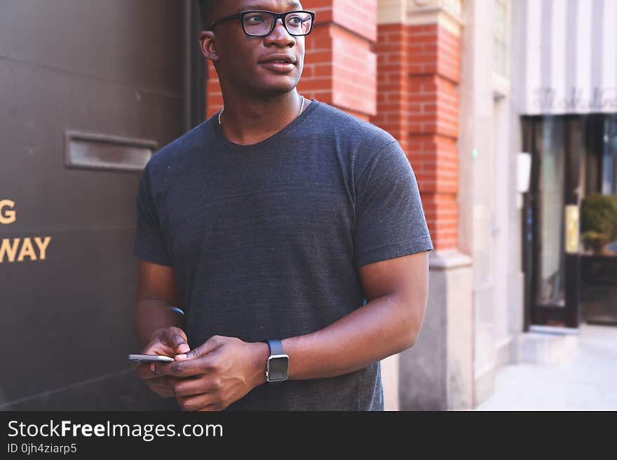 Man in Gray T-shirt Near Black Metal Wall