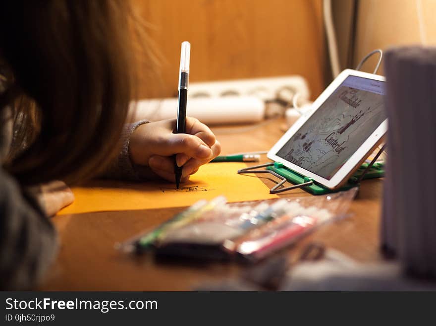 Woman Writing on Orange Paper