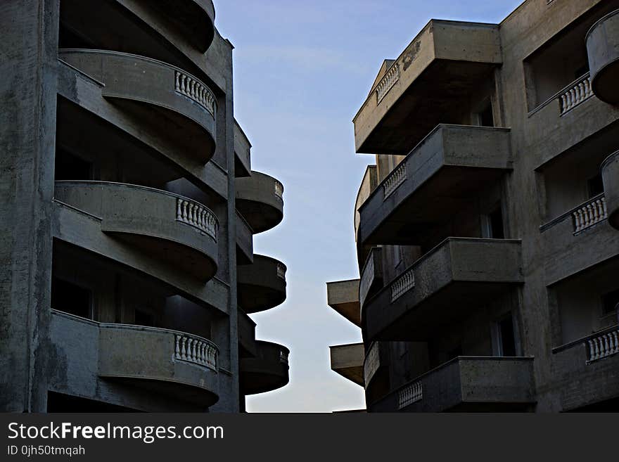 2 Brown High Rise Building Facing Each Other at Daytime