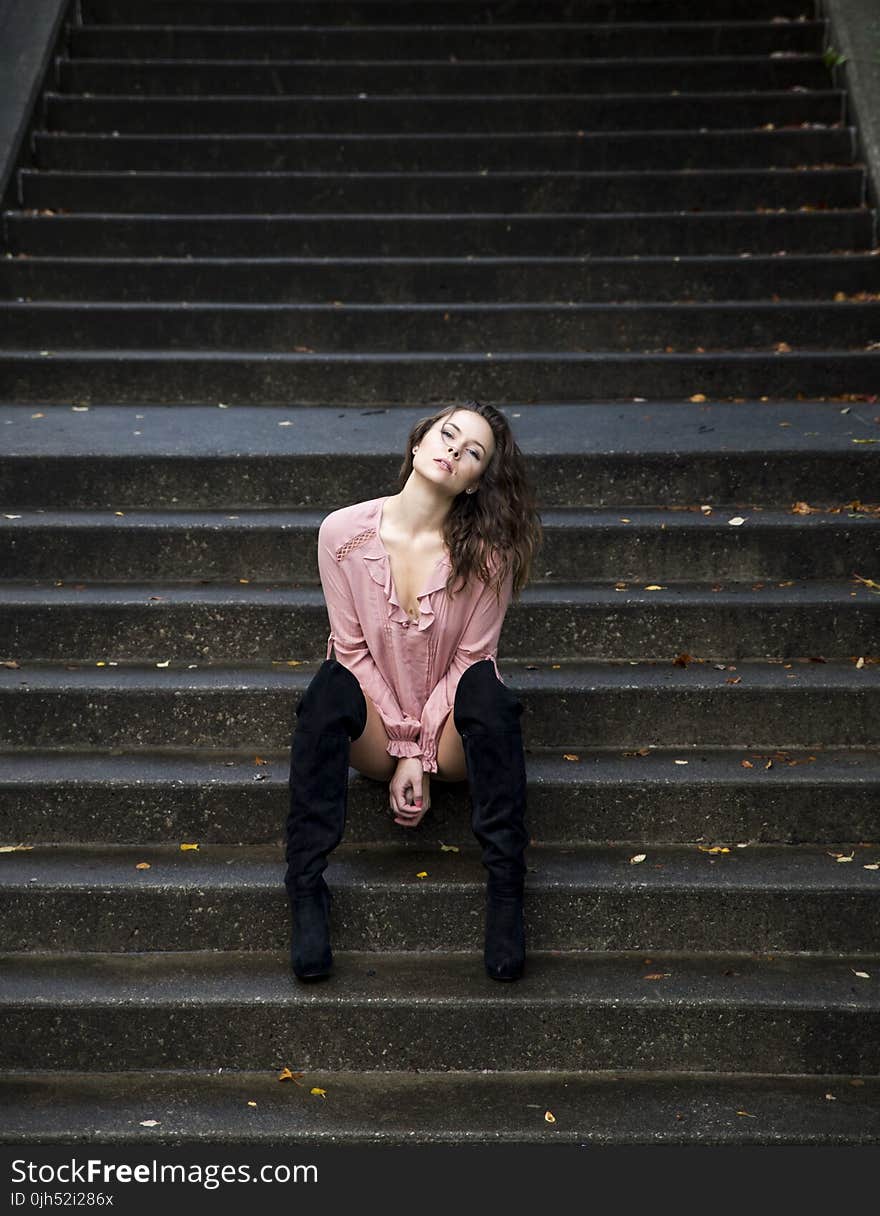 Woman in Pink Dress Shirt Sitting on Stares