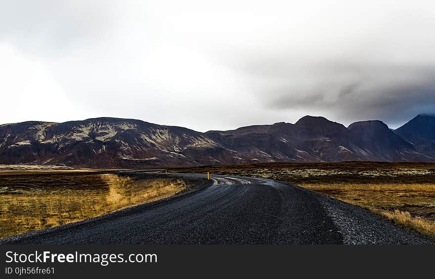 Curve Road Near Mountains during Daytime