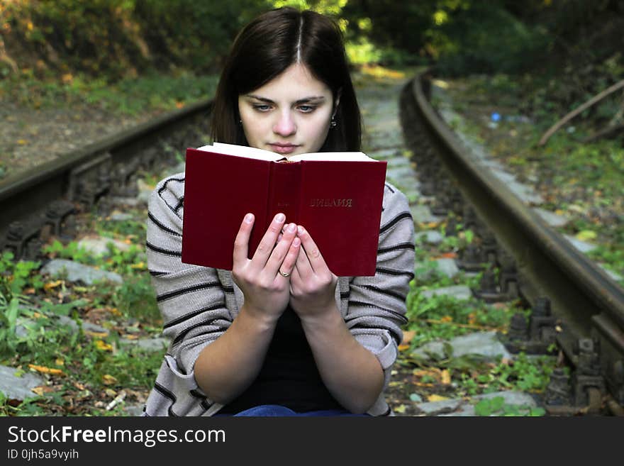 Young Woman Sitting on Bench in Park