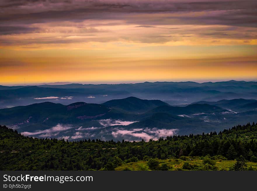 Scenic View of Mountains Against Cloudy Sky