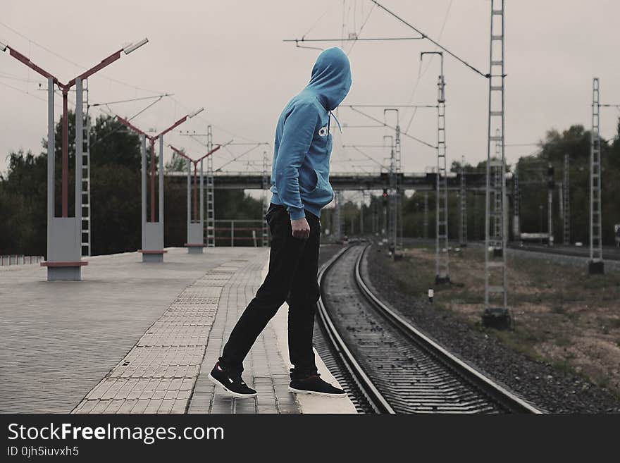 Young Man With Arms Outstretched Against Sky in City