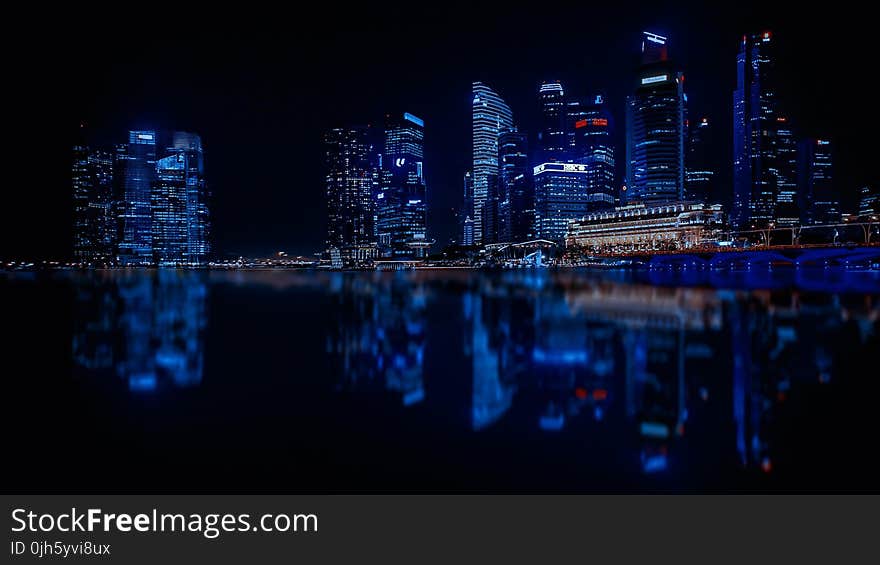 Illuminated Cityscape Against Blue Sky at Night