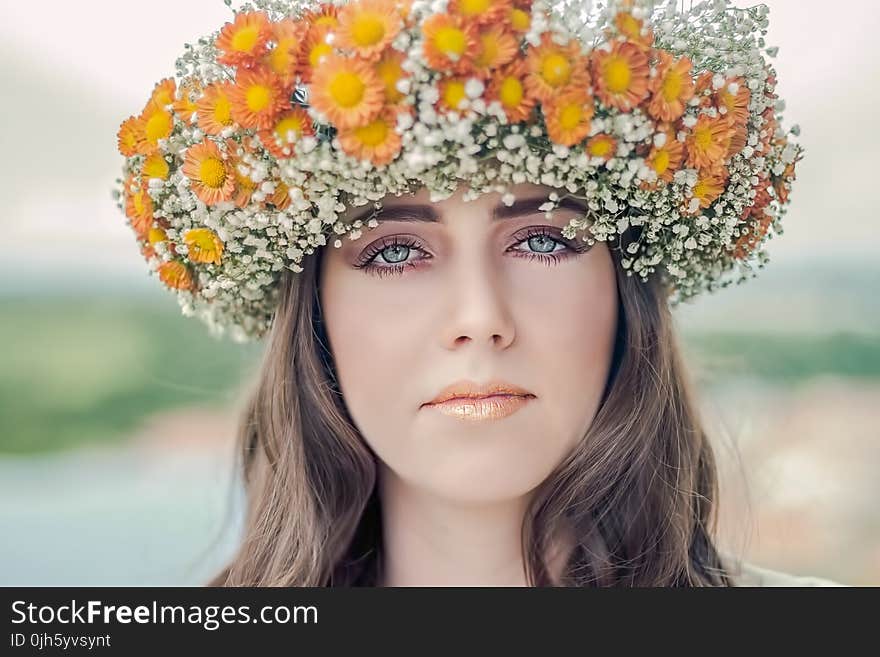 Woman Using White and Orange Floral Hat