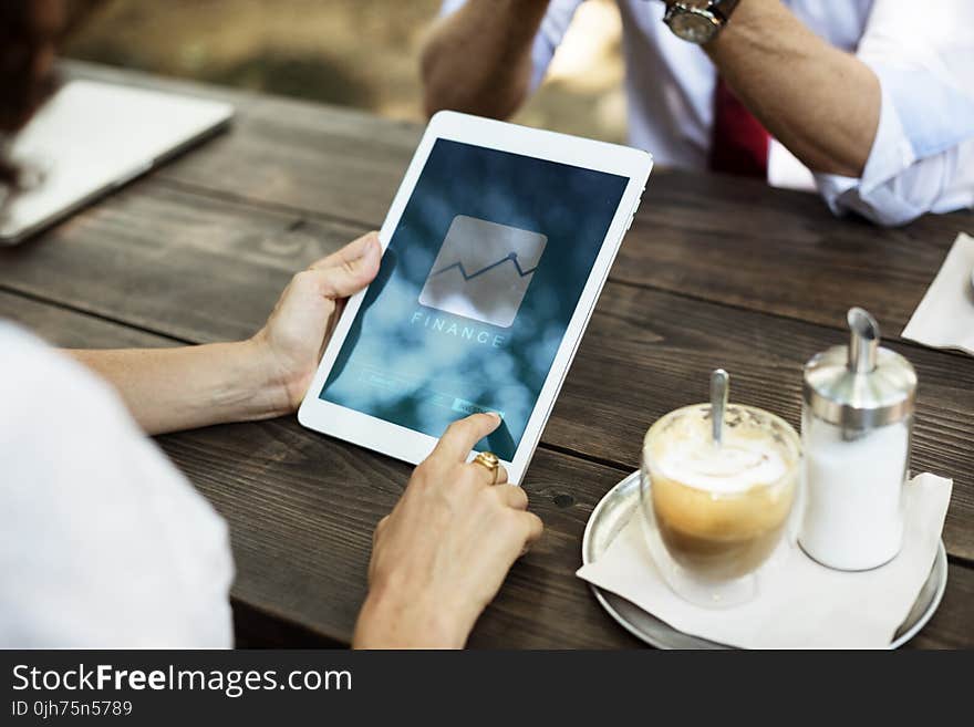 White Tablet Computer on Brown Wooden Table