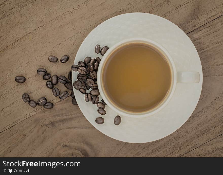 White Ceramic Coffee Cup on Brown Wooden Panel