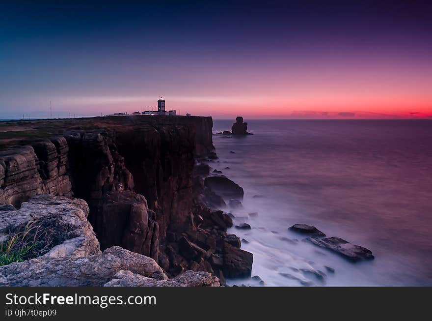 Scenic View Of Ocean Near Cliffs During Dawn