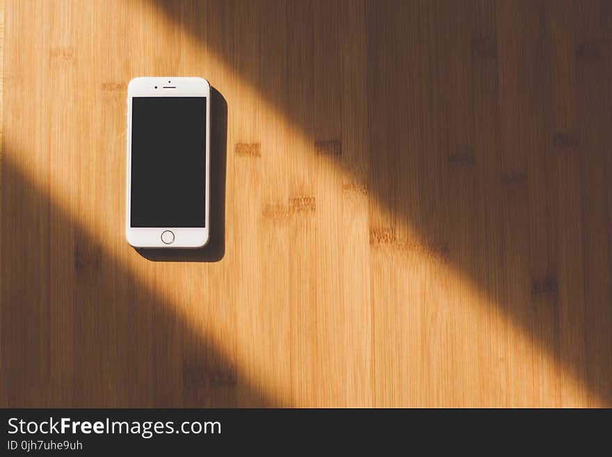 White Apple Iphone on Wooden Table