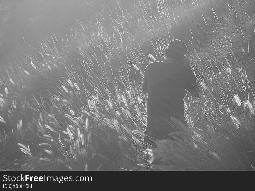 Man Taking Photo on Grass Field in Greyscale Photography