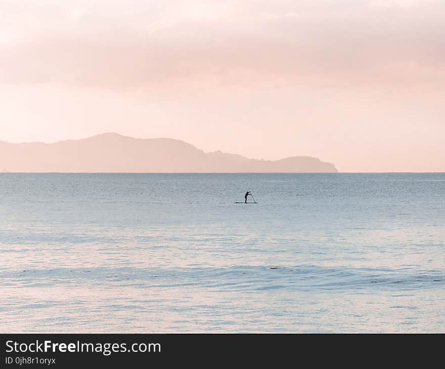 Man Rowing a Boat on Sea at Daytime