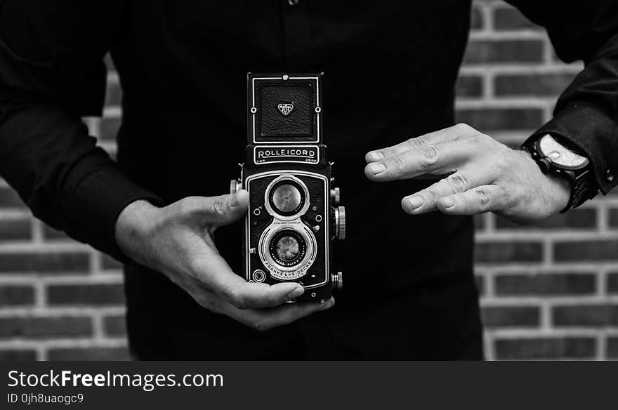 Grayscale Photography of Man Holding Rolleicord Camera