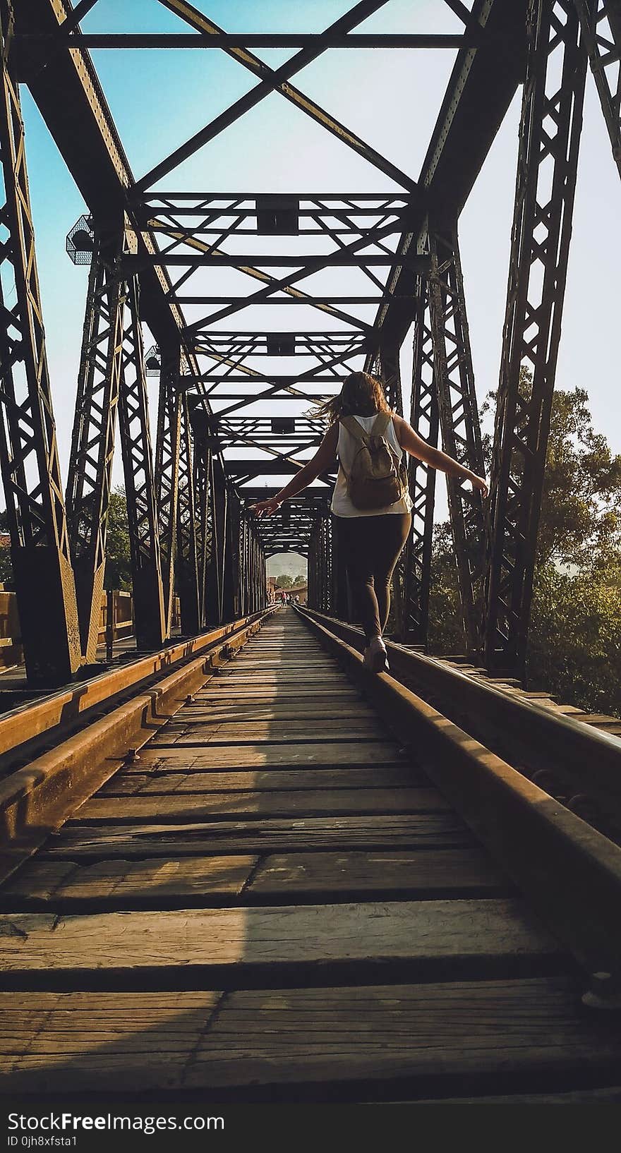 Woman Walking on a Train Rail