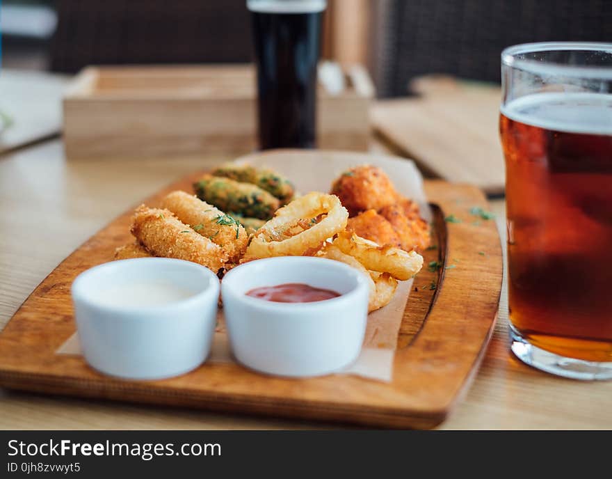 Two White Ceramic Sauce Containers on Brown Wooden Board