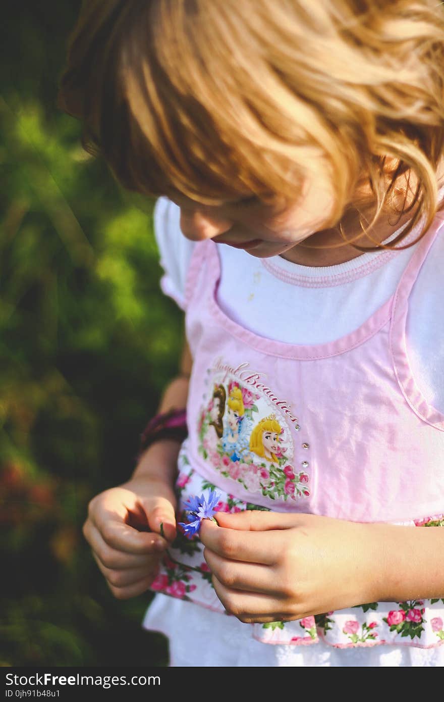 Little girl looks on flower